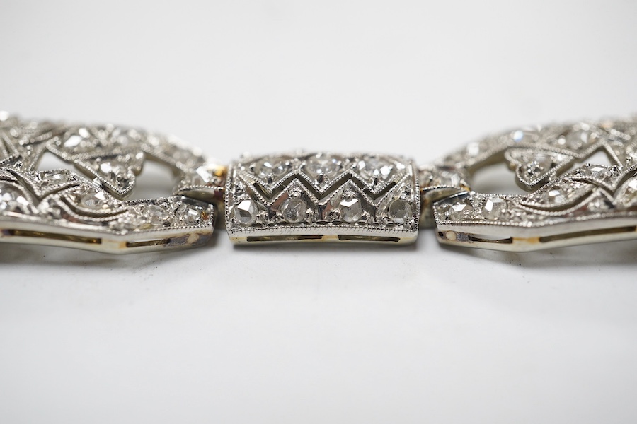 An early 20th century pierced white gold and millegrain set diamond cluster bracelet, set with round and rose cut stones, 18.1cm, gross weight 18.1 grams. Condition - fair to good